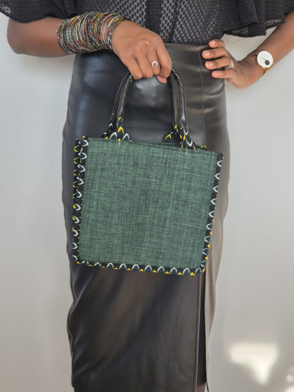 Femme tenant élégant sac à main vert.