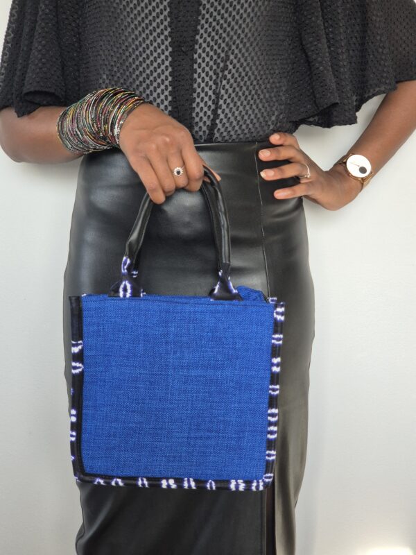 Femme tenant un sac bleu, bijoux colorés.